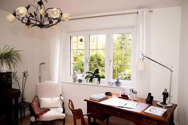 Façade d'une villa moderne française avec de larges baies vitrées et des lignes épurées sous un ciel clair